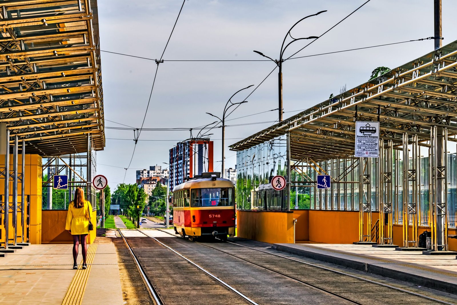 a red and yellow train pulling into a train station